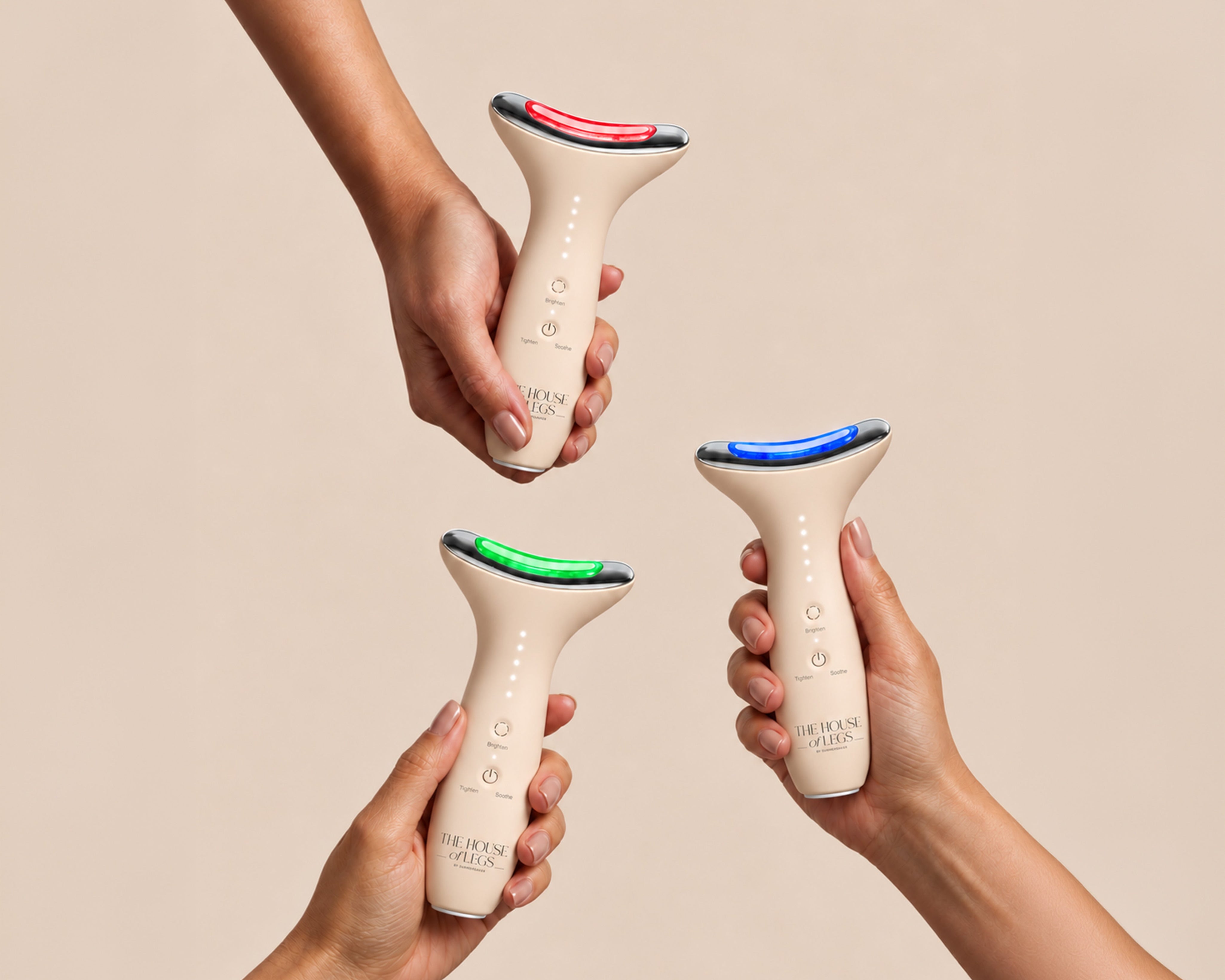 Drei Hände halten das EMS & Light Therapy Device von The House of Legs mit rotem, grünem und blauem Licht