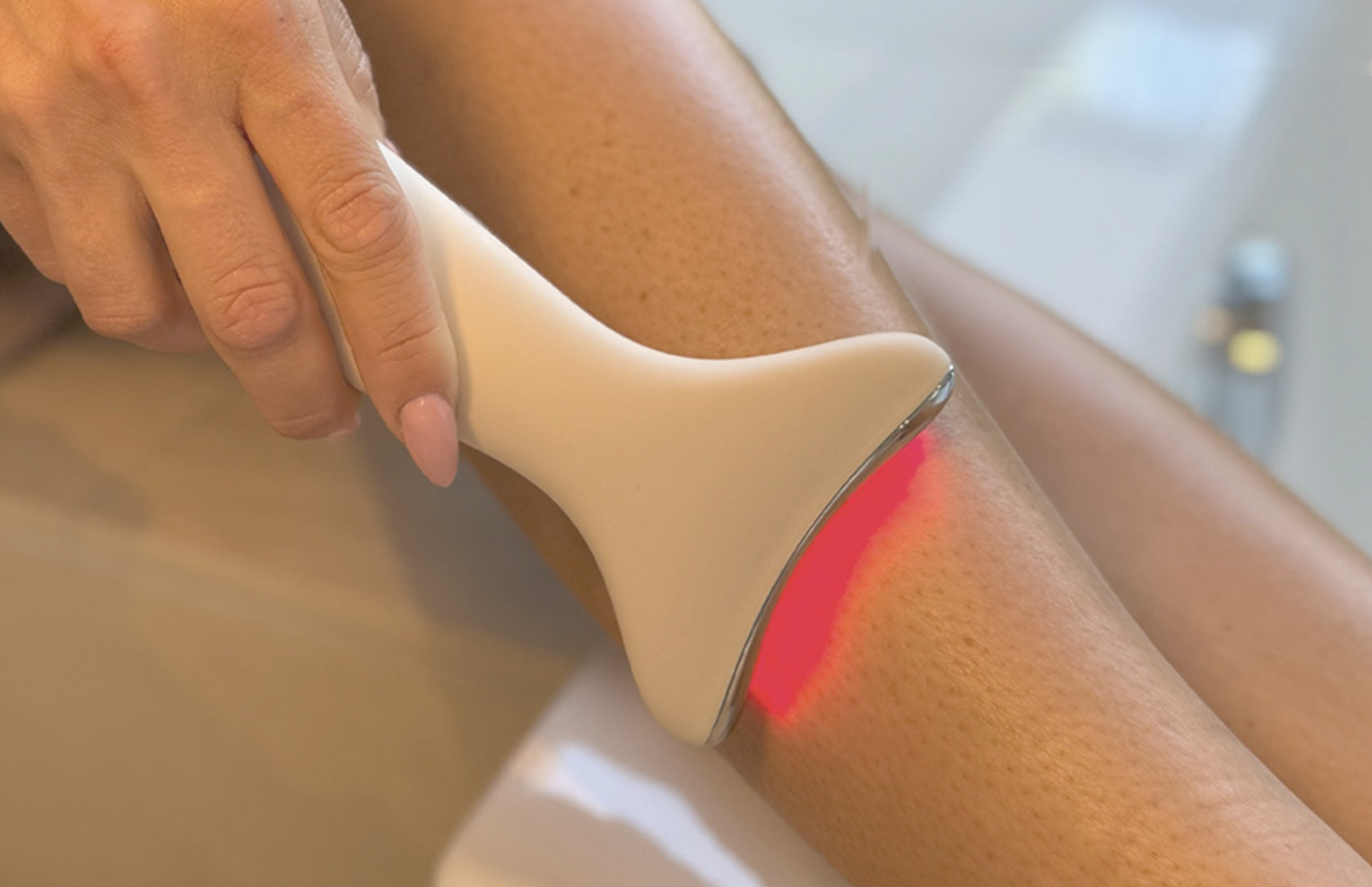 Schritt 2: EMS & Light Therapy Device mit Rotlicht gleitet von unten nach oben über das Bein